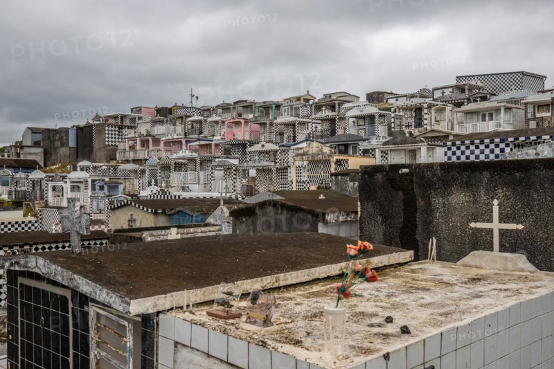 Famous cemetery, many mausoleums or large tombs decorated with tiles, often in black and white. Densely built buildings under a dramatic cloud cover Cimetiere de Morne-a-l'eau, Grand Terre, Guadeloupe, Caribbean, North America