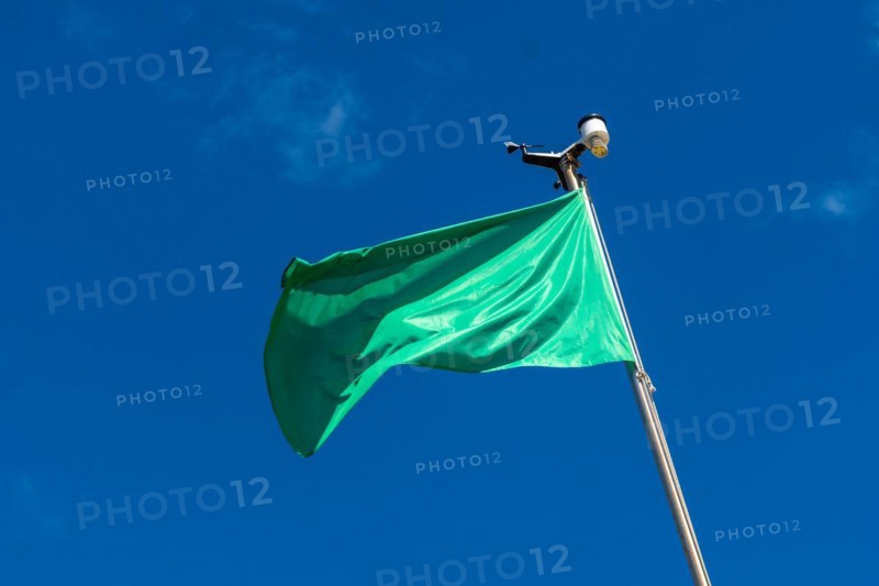 Green flag on the beach in summer summer, lifeguards sign that you can swim