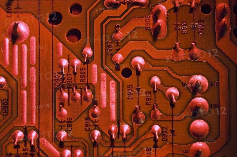 Close-up of red lighted electronic computer circuit board with silver solder points, numbers and lines, Studio Composition, Quebec, Canada, North America