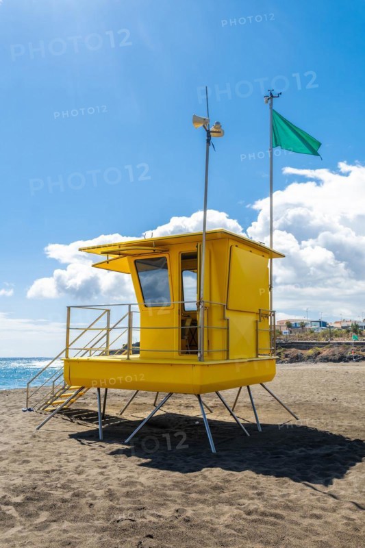 Yellow lifeguard tower in California with green flag