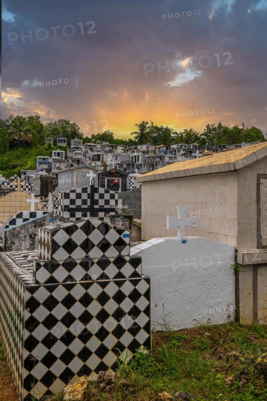 Famous cemetery, many mausoleums or large tombs decorated with tiles, often in black and white. Densely built buildings under a sunset Cimetiere de Morne-a-l'eau, Grand Terre, Guadeloupe, Caribbean, North America