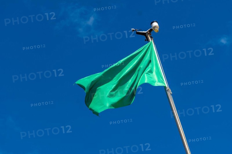 Green flag on the beach in summer summer, lifeguards sign that you can swim