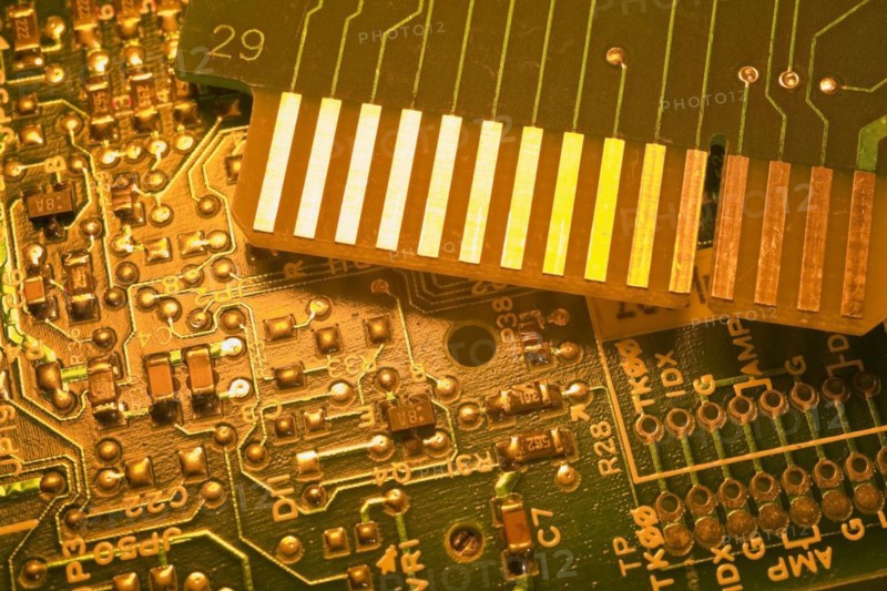 Close-up of golden yellow lighted green electronic computer circuit boards with silver solder points and lines, Studio Composition, Quebec, Canada, North America