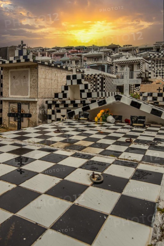 Famous cemetery, many mausoleums or large tombs decorated with tiles, often in black and white. Densely built buildings under a sunset Cimetiere de Morne-a-l'eau, Grand Terre, Guadeloupe, Caribbean, North America