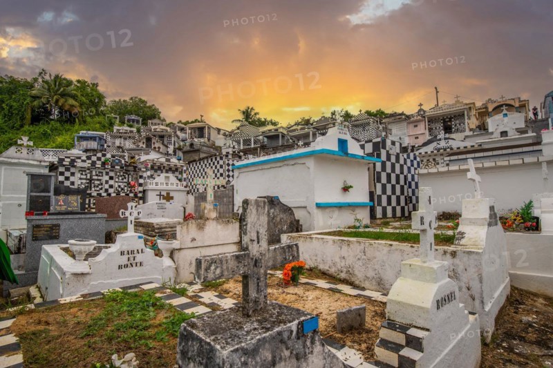 Famous cemetery, many mausoleums or large tombs decorated with tiles, often in black and white. Densely built buildings under a sunset Cimetiere de Morne-a-l'eau, Grand Terre, Guadeloupe, Caribbean, North America