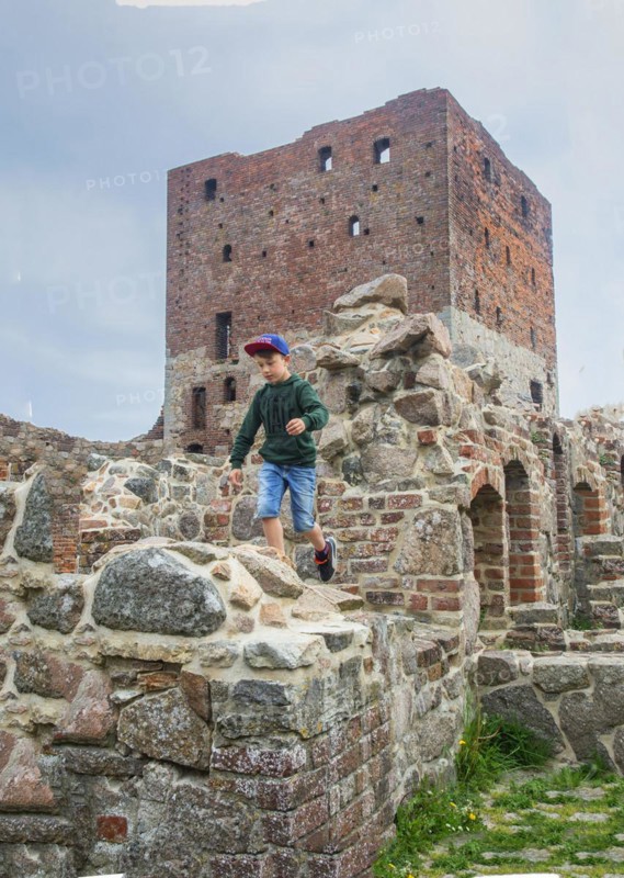 Boy run on Hammershus which was Scandinavia's largest medieval fortification and is one of the largest medieval fortifications in Northern Europe. Now ruin and located on the island Bornholm, Denmark, Baltic Sea, Scandinavia, Europe