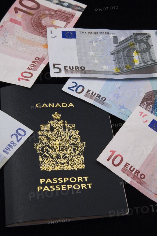Close-up of five, ten, twenty Euro paper currency bank notes on top of Canadian passport on black background, Studio Composition, Quebec, Canada, North America