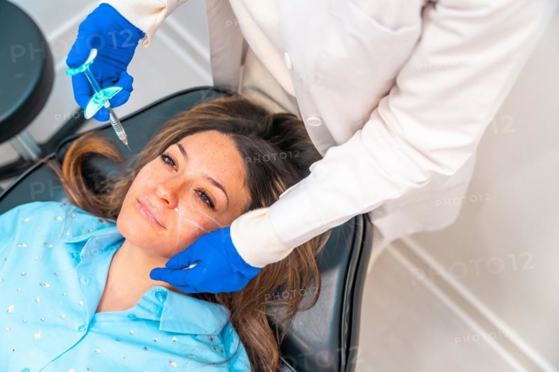 Woman receiving an hyaluronic acid injection to the face in a beauty clinic