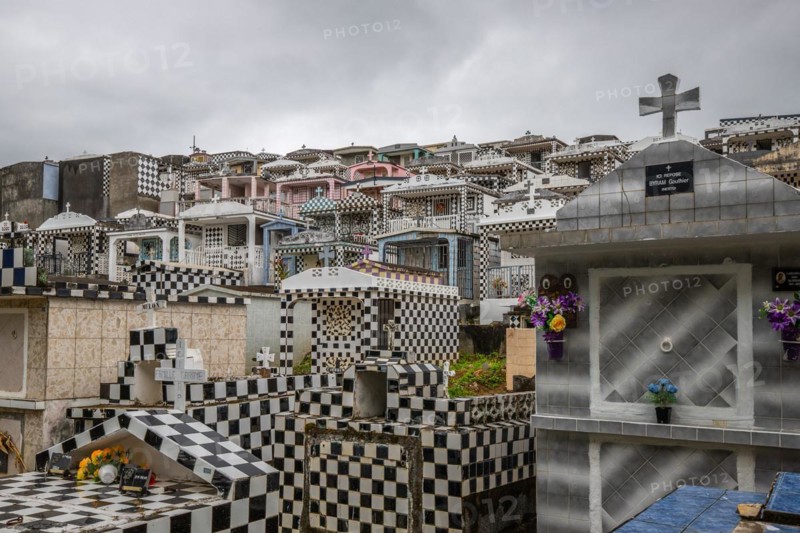 Famous cemetery, many mausoleums or large tombs decorated with tiles, often in black and white. Densely built buildings under a dramatic cloud cover Cimetiere de Morne-a-l'eau, Grand Terre, Guadeloupe, Caribbean, North America