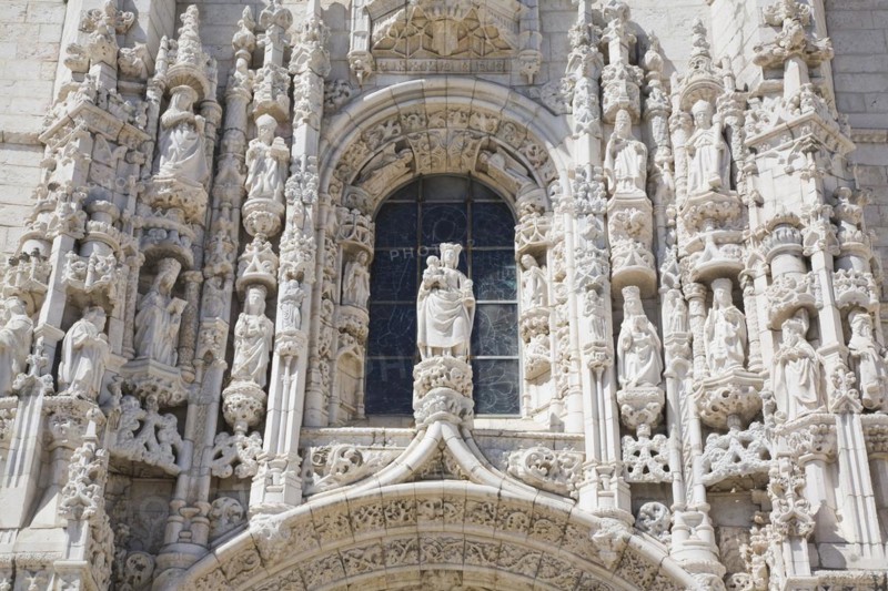 Arched window with decorated carved sculptures on facade of Jeronimos Monastery, Lisbon, Portugal, Europe