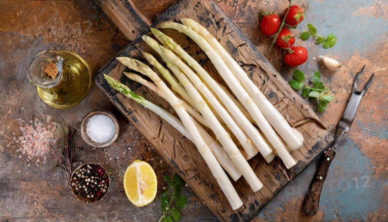 White asparagus on a rustic background with olive oil, lemon wedge and spices, fresh white asparagus, KI generated, AI generated