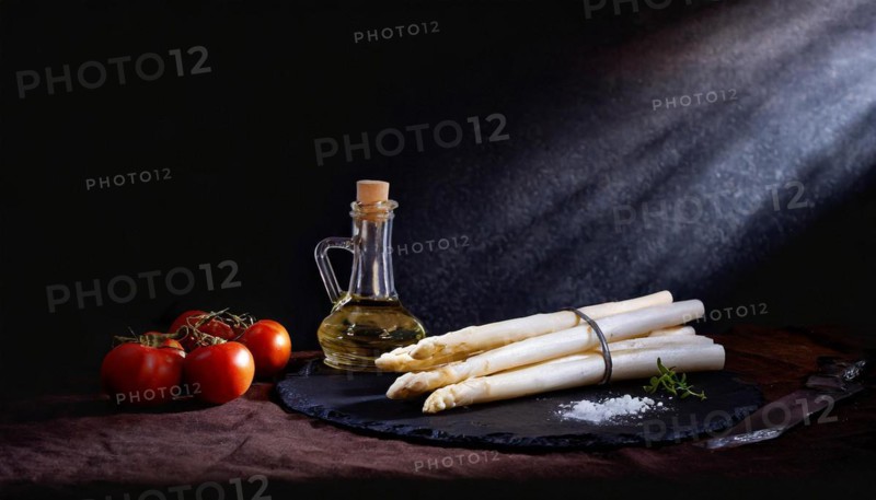Asparagus spears next to olive oil and tomatoes staged with dramatic lighting, AI generated, AI generated