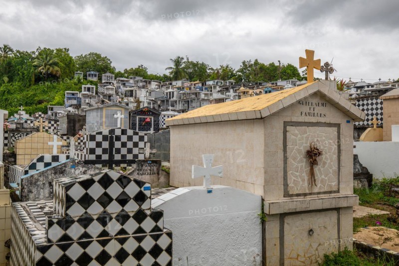 Famous cemetery, many mausoleums or large tombs decorated with tiles, often in black and white. Densely built buildings under a dramatic cloud cover Cimetiere de Morne-a-l'eau, Grand Terre, Guadeloupe, Caribbean, North America