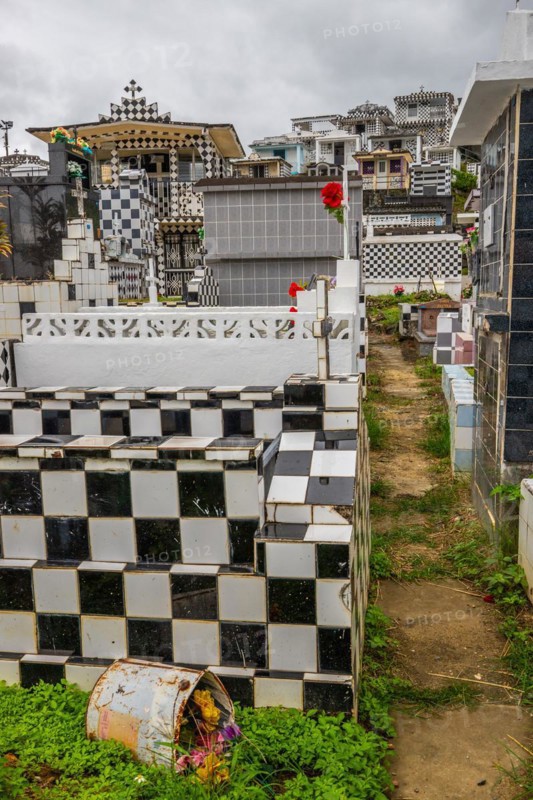 Famous cemetery, many mausoleums or large tombs decorated with tiles, often in black and white. Densely built buildings under a dramatic cloud cover Cimetiere de Morne-a-l'eau, Grand Terre, Guadeloupe, Caribbean, North America