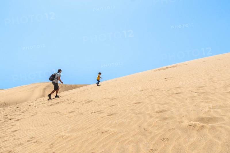 Father and son very happy in the dunes of Maspalomas, Gran Canaria, Canary Islands