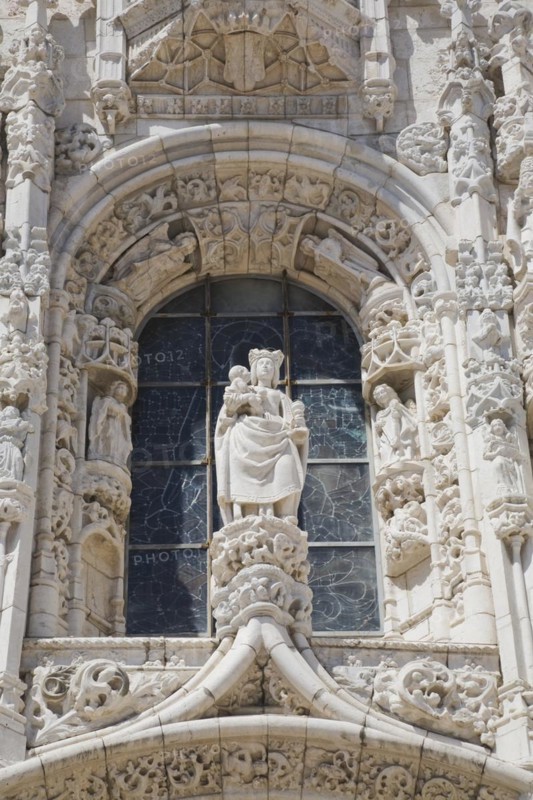 Arched window decorated with carved sculptures on facade of Jeronimos Monastery, Lisbon, Portugal, Europe