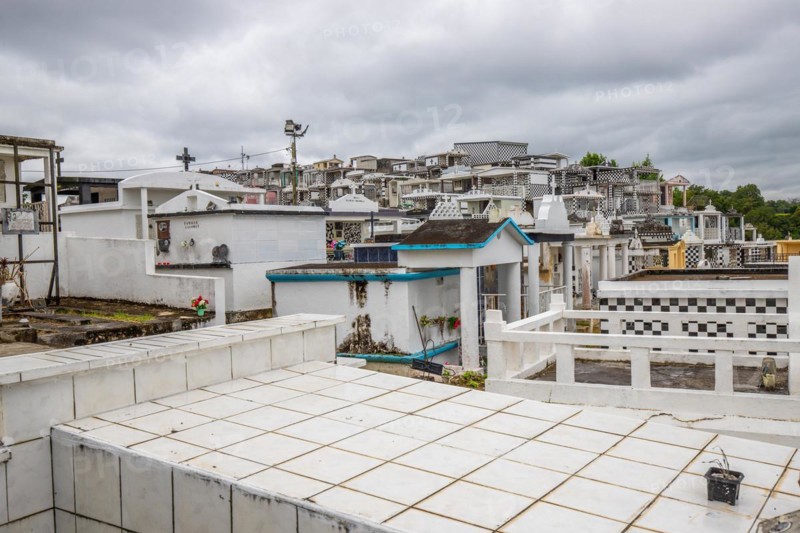 Famous cemetery, many mausoleums or large tombs decorated with tiles, often in black and white. Densely built buildings under a dramatic cloud cover Cimetiere de Morne-a-l'eau, Grand Terre, Guadeloupe, Caribbean, North America