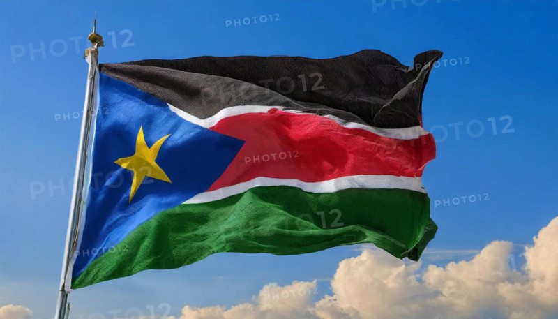 The flag of South Sudan, fluttering in the wind, isolated, against the blue sky