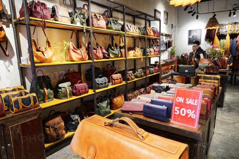 Strolling through the restored Tianzifang neighbourhood, interior view of a shop full of different leather bags with sales sign, Shanghai, China, Asia