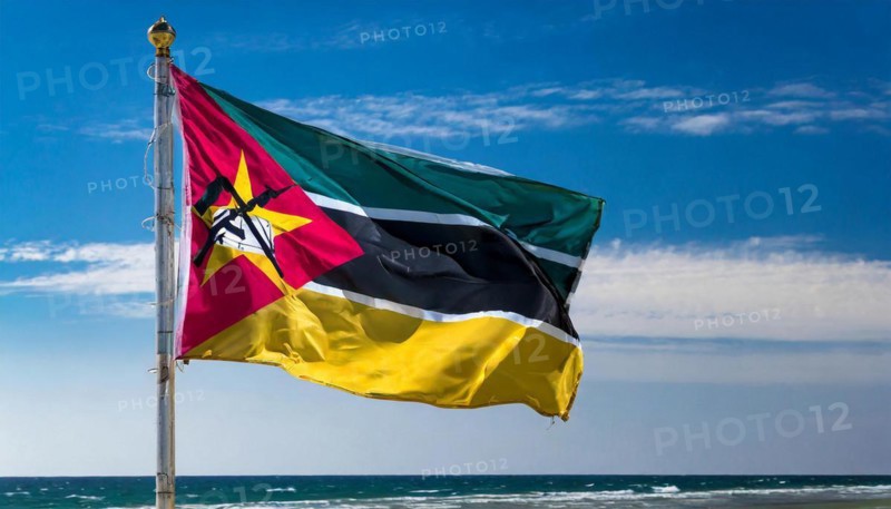 The flag of Mozambique, fluttering in the wind, isolated, against the blue sky