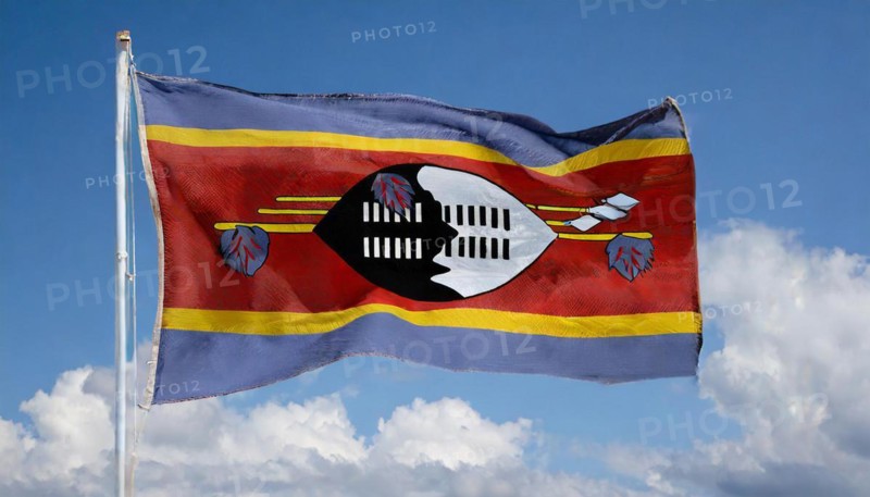 The flag of Swaziland, Kingdom of Eswatini, flutters in the wind, isolated, against the blue sky