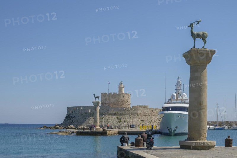 Elafos and Elafina, stag and hind, sculptures on columns, harbour entrance Mandraki harbour, fortress Agios Nikolaos with lighthouse, Rhodes, Dodecanese archipelago, Greek Islands, Greece, Europe