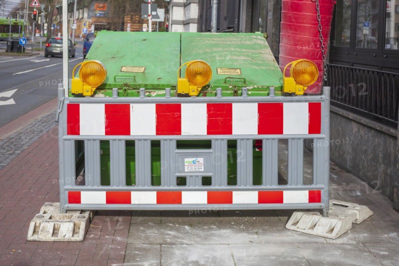 Construction site with barrier and waste container or skip for building rubble on a footpath, Germany, Europe