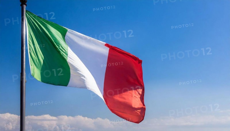 The flag of Italy flutters in the wind, isolated against a blue sky