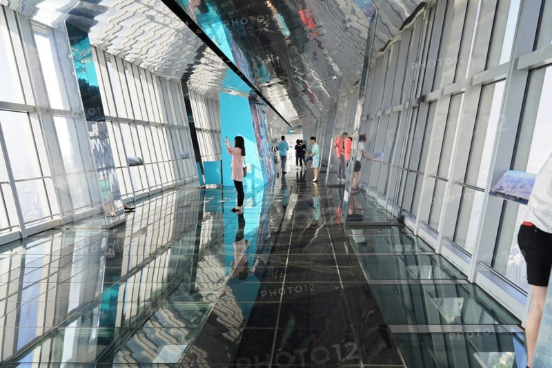 Viewing terrace, The Bottle Opener at 492 metres, people walk along a glass viewing corridor with reflections on the wall and ceiling, Shanghai, China, Asia