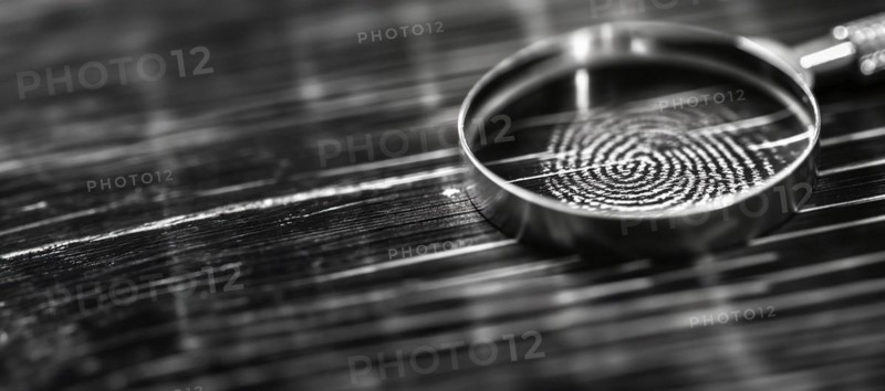Banner of magnifying glass resting on a fingerprint on paper. generative AI, AI generated