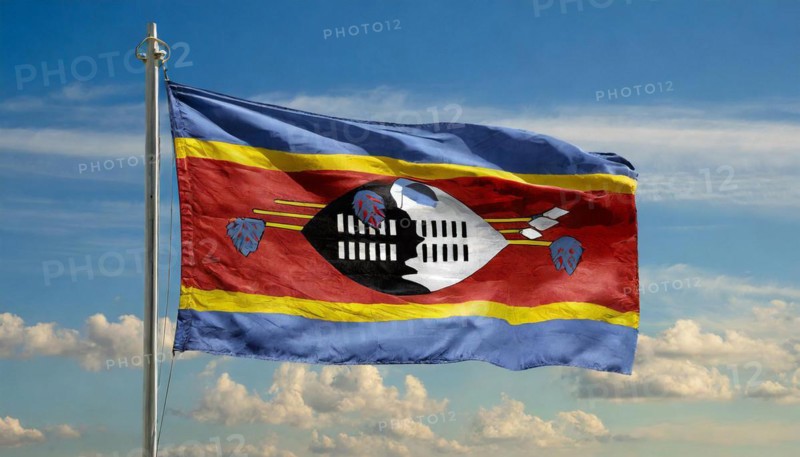 The flag of Swaziland, Kingdom of Eswatini, flutters in the wind, isolated, against the blue sky