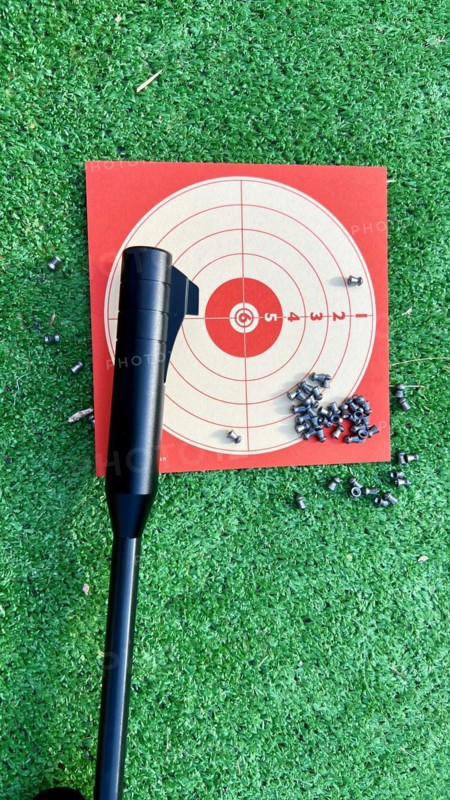 Air rifle for training with its target and its pellets on the grass