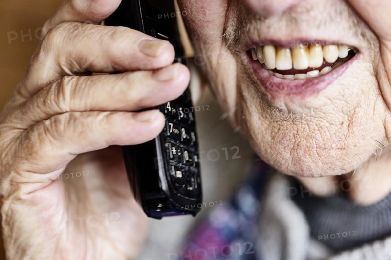 Mouth, hands and telephone receiver of a senior citizen making a phone call, close-up, Cologne, North Rhine-Westphalia, Germany, Europe