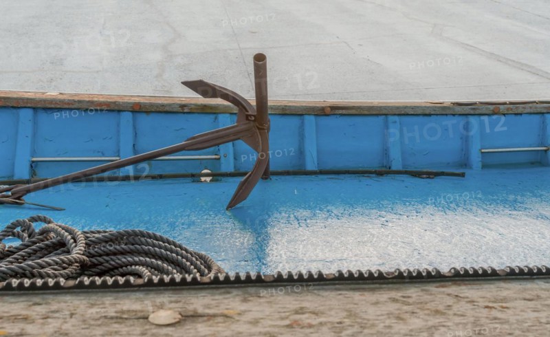 Anchor and rope laying on deck of dry docked fishing boat in South Korea