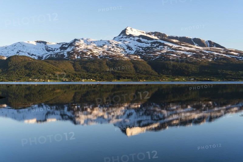 Landscape in Norway. The Balsfjord with a view of Mount Fugltinden. At night during the midnight sun, good weather, blue sky. Early summer. Reflection. Balsfjord, Norway, Europe