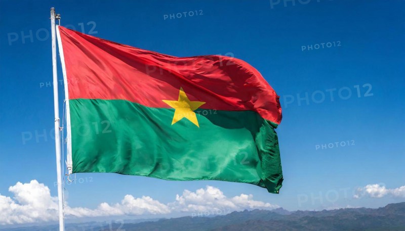 The flag of Burkina Faso flutters in the wind, isolated against the blue sky