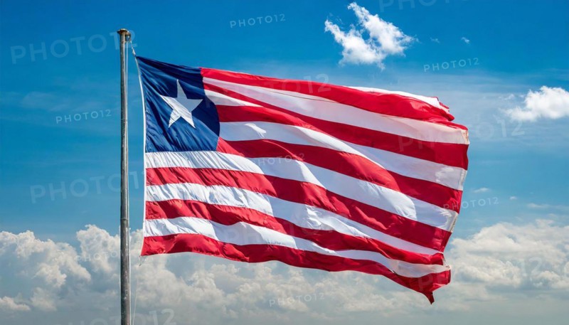 The flag of Liberia, fluttering in the wind, isolated, against the blue sky