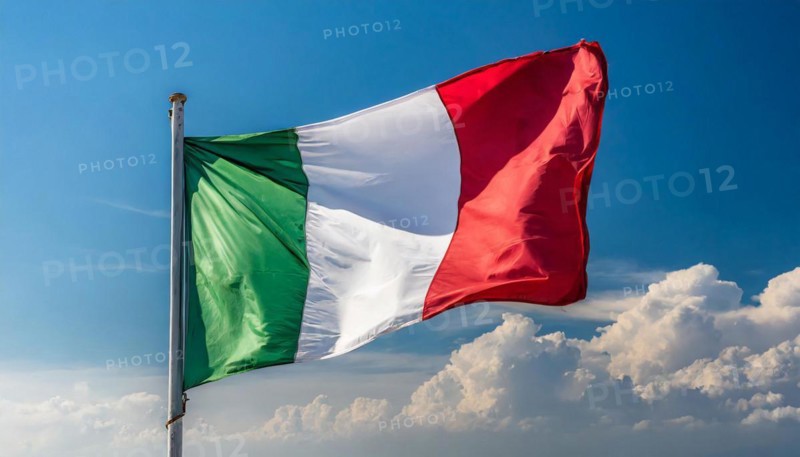 The flag of Italy flutters in the wind, isolated against a blue sky