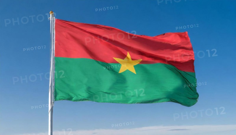 The flag of Burkina Faso flutters in the wind, isolated against the blue sky