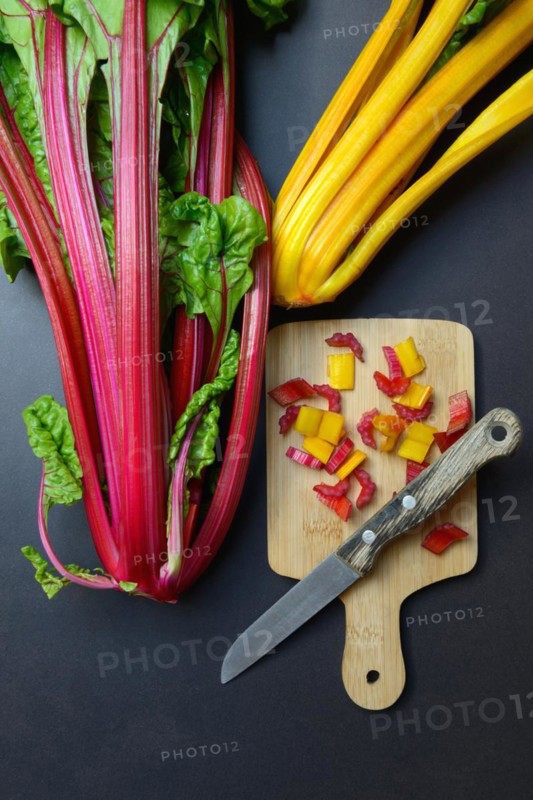 Swiss chard, chopped stems on wooden board with knife, Beta vulgaris