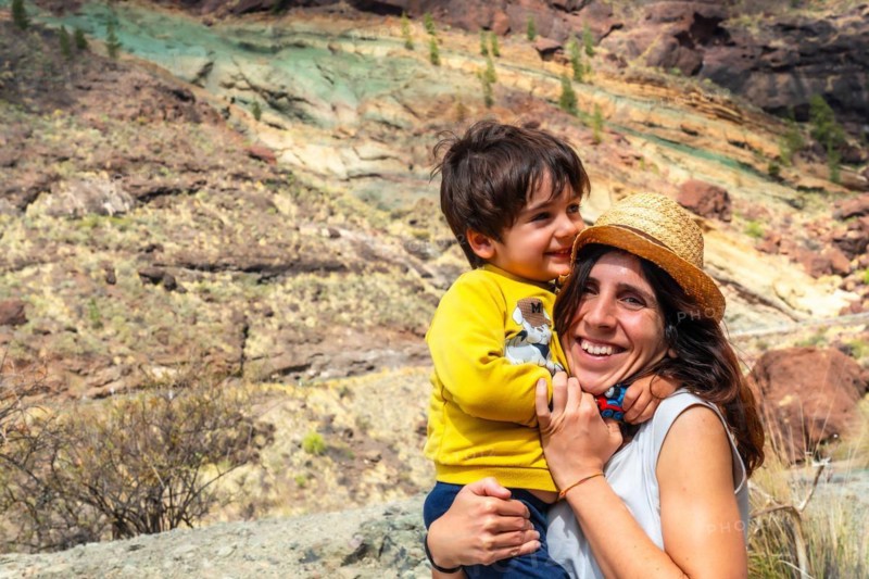 Family of mother and son enjoying at the Natural Monument Azulejos de Veneguera or Rainbow Rocks in Mogan, Gran Canaria