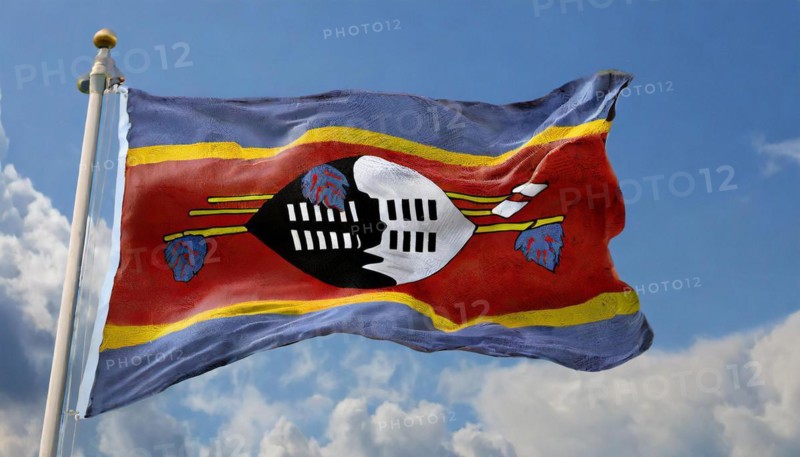 The flag of Swaziland, Kingdom of Eswatini, flutters in the wind, isolated, against the blue sky