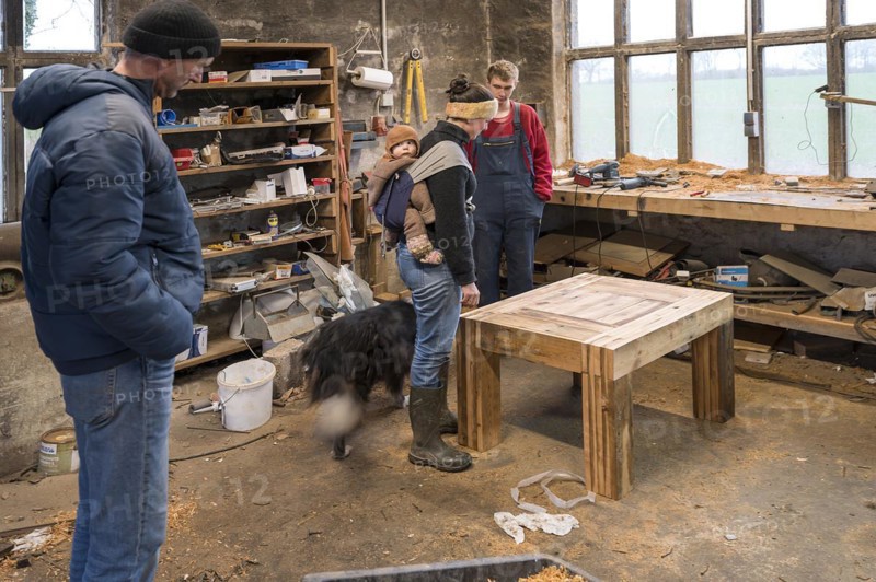 Family inspecting the table built by their son in the workshop, Mecklenburg-Vorpommern, Germany, Europe