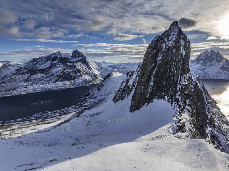 Aerial view of Bergen by the sea, fjord, sunbeams, winter, snow, Mount Segla, Senja, Troms, NorwayDefault