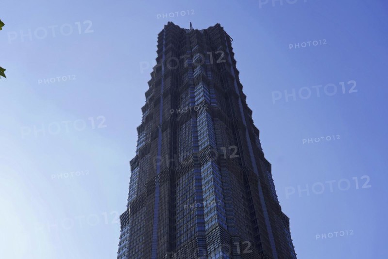The facade of a geometrically designed skyscraper stands out against the blue sky, Shanghai, China, Asia