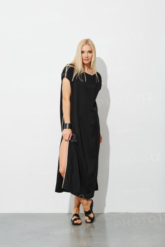 Charming blonde woman in black sleeveless dress and leather sandals