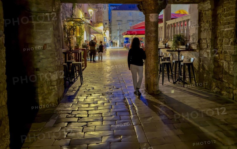 Person walking along a cobblestone street at night, Trogir, Dalmatia, Croatia, Europe