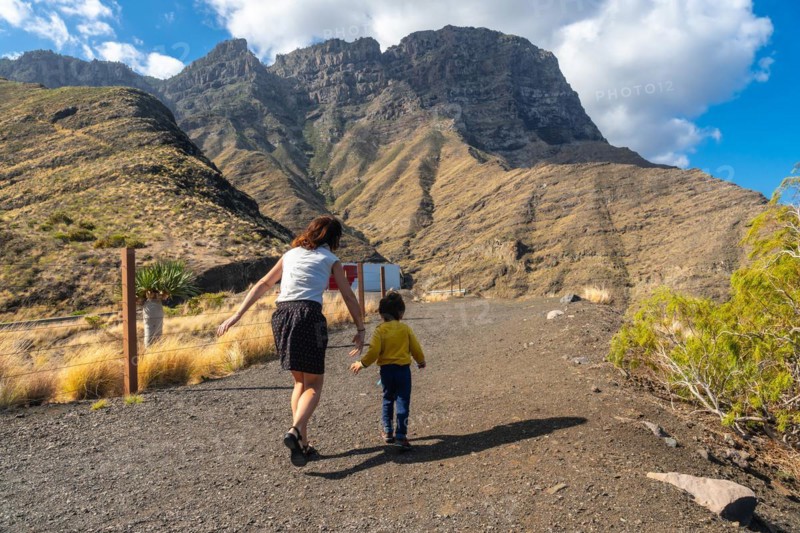A mother and her son walking and having fun in the mountains of the Agaete coast, Roque Guayedra, Gran Canaria