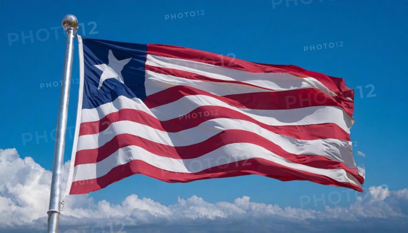 The flag of Liberia, fluttering in the wind, isolated, against the blue sky
