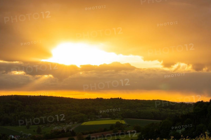 Landscape at sunrise. Beautiful morning landscape with fresh yellow rape fields in spring. Small castle in the yellow fields on a hill. Historic Ronneburg Castle in the middle of nature, Ronneburg, Hesse, Germany, Europe